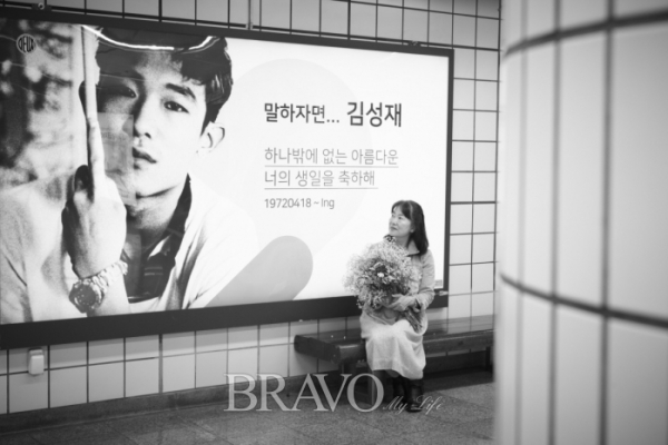 ▲서울지하철 5호선 여의도역에 김성재 팬들이 마련한 생일축하 광고판 앞에 앉은 육미승 동년기자. (사진 박규민 parkkyumin@gmail.com)