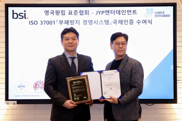 ▲JYP엔터테인먼트 정욱 대표이사(오른쪽)과 BSI Korea 임성환 대표가 JYP 본사에서 개최된 부패방지 경영시스템(ISO 37001) 국제 인증 수여식을 마치고 기념 촬영을 하고 있다.(사진제공=JYP엔터테인먼트)