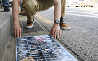 [포토] 바닥에 부착되는 '배수구 쓰레기 투기 금지' 포스터