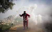 [포토] 최루탄 던지는 산타 복장의 팔레스타인 남성