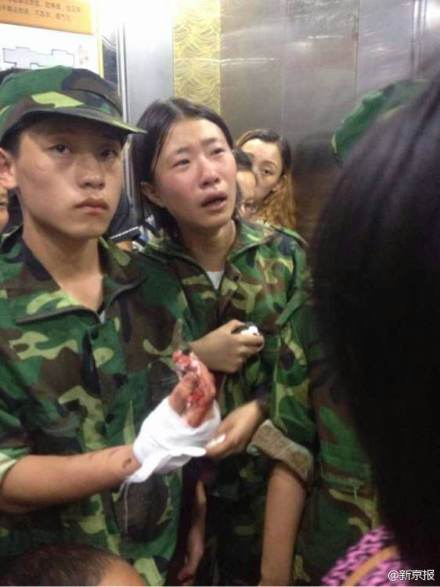 ▲25일(현지시간) 중국 후난성 중ㆍ고등학교에서 군사훈련을 받던 학생과 교관이 충돌해 40여명이 부상당했다. 사진은 피를 흘리는 남학생과 상황을 설명하는 여학생의 모습. (사진=중국신경보 캡처)