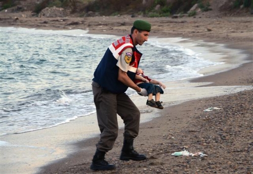 ▲터키 해변에서 주검으로 발견된 세살배기 시리아 아기 아일란 쿠르디을 옮기고 있는 현지 경찰의 모습. 사진출처=AP/뉴시스 