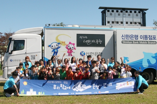 ▲지난 8일 전라북도 남원시 금지동초등학교에서 진행된 '찾아가는 금융체험교육'에 참가한 학생들과 직원들이 기념촬영을 하고 있다.(사진 제공 = 신한은행)