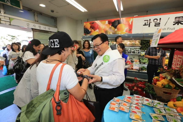 ▲이동필 농림축산식품부 장관이 지난 14일 일본 도쿄에 있는 한국 식품 판매점 ‘한국광장’에서 1일 점원으로 나서 파프리카 시식회를 운영했다.(농림축산식품부 제공)
