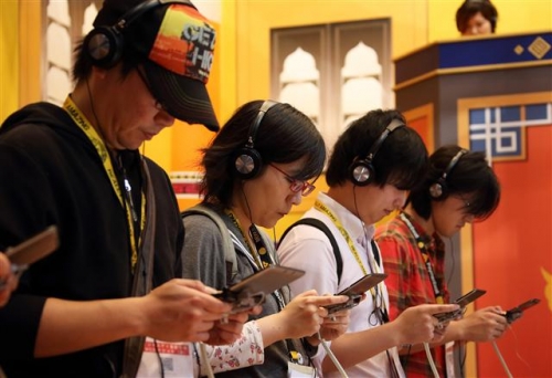 ▲일본 도쿄게임쇼가 17일(현지시간) 개막한 가운데 참관객들이 닌텐도의 3DS LL로 게임을 즐기고 있다. 블룸버그