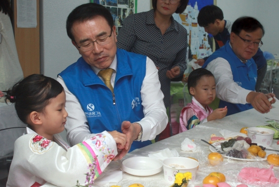 ▲신한은행 조용병 은행장이 임원들과 함께 22일 서울 중구 남산원에 방문해 아이들과 송편을 빚고 있다.(사진 제공 = 신한은행)