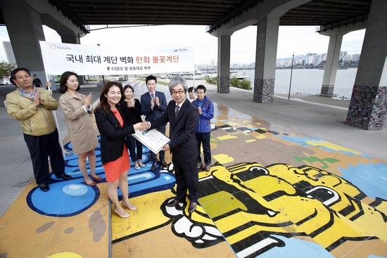 ▲30일 원효대교 남단 하부에서 한화그룹이 조성한 ‘한화 불꽃계단’이 한국기록원으로부터 국내 최대 계단벽화로 인증받고 있다.(사진제공=한화)