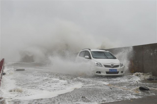 ▲중국 푸젠성에 29일(현지시간) 상륙한 21호 태풍 두쥐안의 영향으로 물바다가 된 도로를 한 차량이 지나가고 있다. 신화/뉴시스