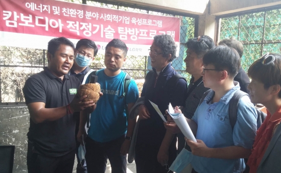 ▲7일(현지시간) 캄보디아 사회적기업 SGFE 관계자가 연수단에게 코코넛 껍질을 활용해 목탄을 만드는 원리를 설명하고 있다. (사진제공=LG전자 )