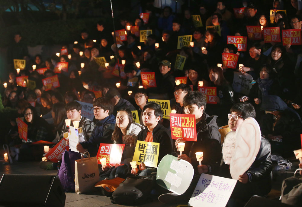 ▲ 3일 오후 서울 청계광장 인근에서 한국사교과서국정화저지네트워크 관계자들이 결의대회를 열고 촛불과 '한국사 교과서 국정화 저지!' 등의 메시지가 적힌 손팻말을 들고 있다.(사진=연합뉴스)