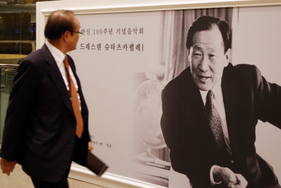 ▲18일 저녁 서울 서초구 예술의 전당 콘서트홀에서 열린 故 정주영 탄생 100주년 기념음악회에서 한 관객이 故 정주영 회장의 사진 앞을 지나고 있다.(연합뉴스)