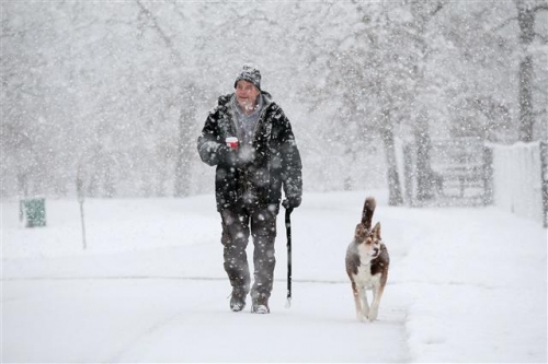 ▲미국 일리노이 주 엘진에서 한 남성이 자신의 애완견과 함께 21일(현지시간) 눈 내리는 거리를 걷고 있다. AP/뉴시스