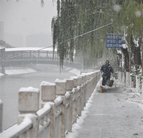 ▲중국 베이징에 22일(현지시간) 이례적인 폭설이 내리는 가운데 환경미화원이 쌓인 눈을 치우고 있다. 신화/뉴시스