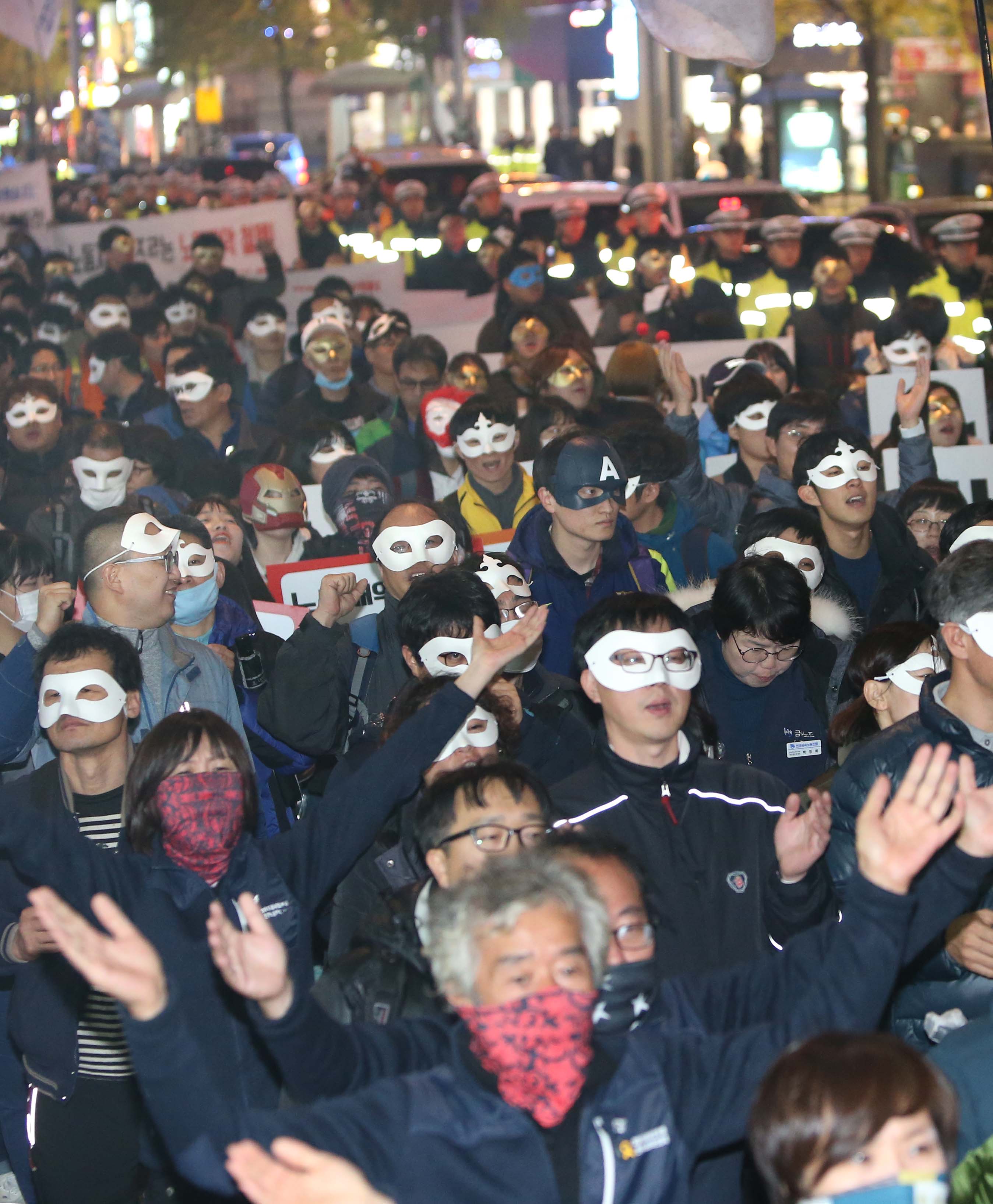 ▲민주노총 부산본부가 2일 부산 부산진구 쥬디스 태화 앞에서 마련한 총파업투쟁 2차 결의대회에 참가한 시위대가 복면을 쓴 채 정부의 노동법 개악과 '복면금지법'을 규탄하며 거리행진을 벌이고 있다. (사진=연합뉴스)