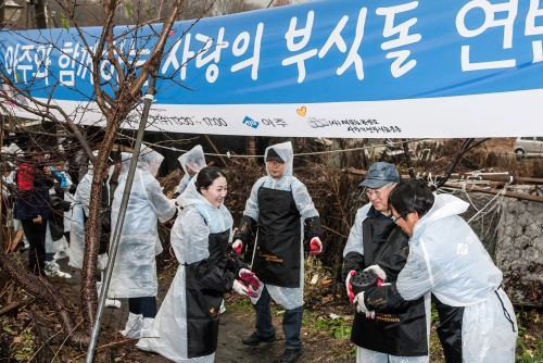 ▲지난 2일 아주그룹 문규영 회장(오른쪽 두 번째)과 임직원들이 서울 남태령 전원마을 지역사회 이웃들의 따뜻한 겨울나기를 위한 ‘사랑의 부싯돌’ 현장에서 줄지어 연탄을 나르고 있다.(사진제공=아주그룹)