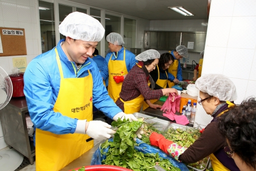 ▲동아제약 본사 직원들이 자원봉사자들과 함께 취약계층 대상에게 배달할 밑반찬을 조리하고 있다.(사진=동아제약)