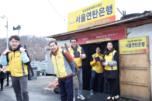 ▲10일 OCI 배정권 부사장(왼쪽 두 번째)과 신입사원이 지게를 지고 연탄을 배달하고 있다.(사진제공=OCI)