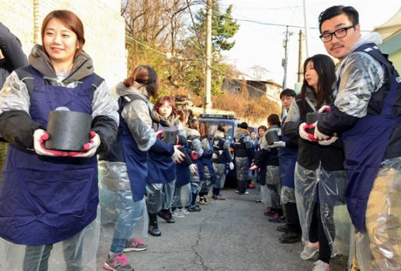 ▲이디야커피 임직원들이 지난 9일 서울 성북구 정릉3동 일대에서 사랑의 쌀·연탄 나눔 봉사활동을 하고 있다.  사진제공 이디야커피
