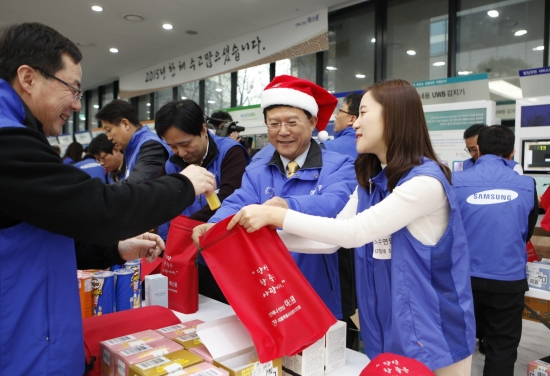 ▲24일 개최된 에스원 나눔 종무식에서 육현표 사장(가운데)이 임직원들과 함께 지역아동센터에 전달할 크리스마스 나눔 키트를 제작하고 있다.(사진=에스원)