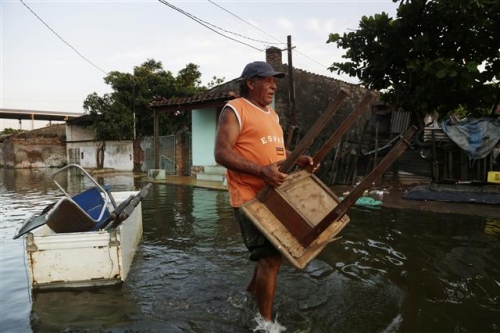 ▲파라과이 아순시온 주민들이 홍수로 젖은 가구를 23일(현지시간) 운반하고 있다. AP/뉴시스