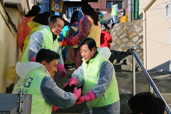 ▲ HUG 김선덕 사장(앞줄 오른쪽)을 비롯한 임직원과 대학생 봉사단 40여명이 함께 연탄 나르기 봉사활동을(사진=HUG주택도시보증공사)
