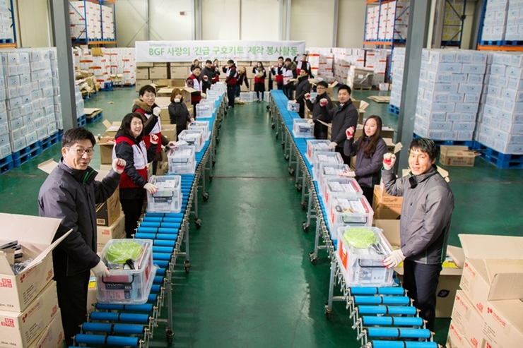 ▲BGF리테일 임직원과 국민안전처, 재해구호협회 관계자, 자원봉사자들이 ‘BGF 사랑의 긴급구호키트’ 제작했다.(사진제공=BGF리테일)