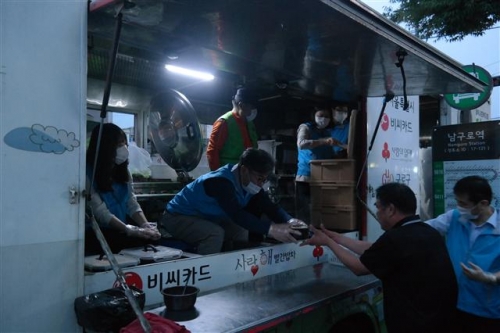 ▲지난해 6월 건설근로자공제회 임직원들이 서울 남구로역 인근에서 '희망식당 빨간밥차' 배식 자원봉사활동을 하고 있는 모습.