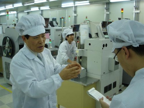 ▲이진효(왼쪽) 알에프세미 대표가 전주에 있는 ECM칩 생산 공장을 둘러보고 있다. 사진제공 알에프세미