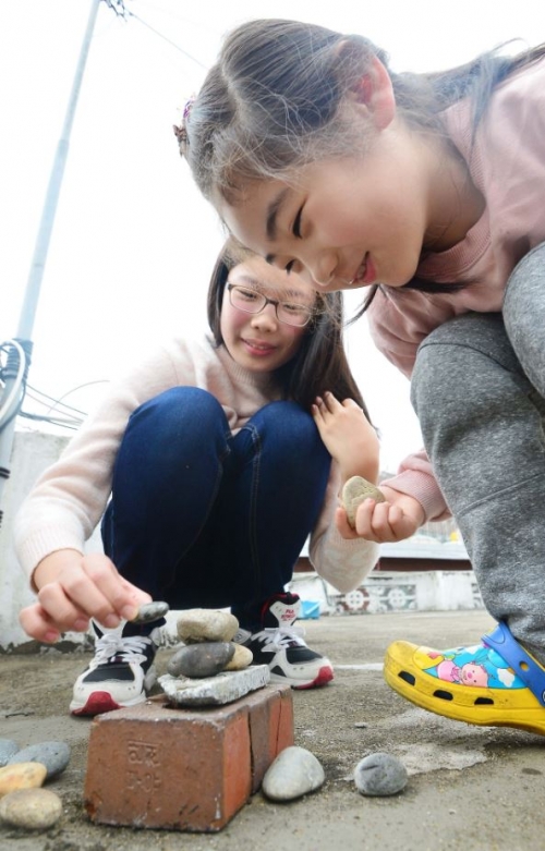 ▲풍자희 어린이가 자원봉사자인 홍주영 학생과 함께 돌 쌓기 놀이를 하고 있다.
