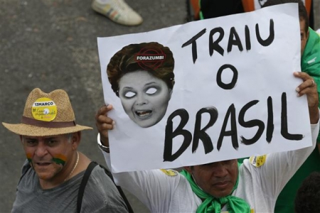 ▲브라질 전역에서 13일(현지시간) 대규모 시위가 발생한 가운데 한 시위 참가자가 지우마 호세프 얼굴과 함께 &quot;브라질을 배신했다&quot;는 문구가 담긴 플래카드를 들어보이고 있다. 사진=AP뉴시스