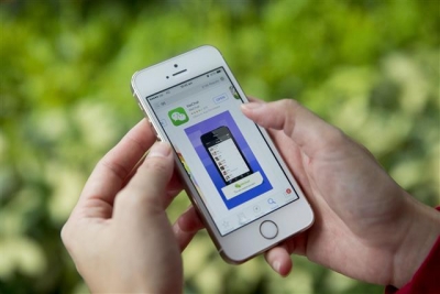 ▲스마트폰 사용자가 스마트폰에 텐센트가 보유하고 있는 메신저 앱 '위챗'을 다운로드 받고 있는 모습. 사진출처=블룸버그 