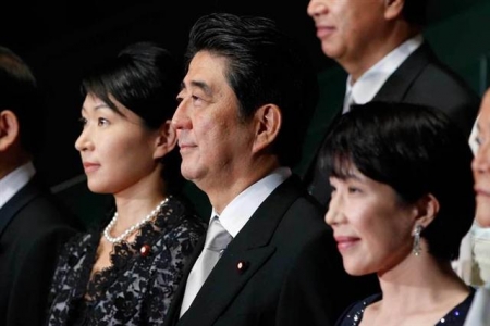 ▲아베 신조 일본 총리가 지난 2014년 10월 새 내각 여성 각료들 사이에서 사진을 촬영하고 있는 모습. 사진=블룸버그 