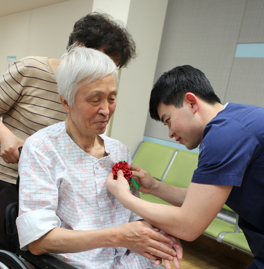 ▲지난 18일 서남병원이 진행한 카네이션 사랑 나눔 행사에서, 병원 임직원이 환자의 가슴에 꽃을 달아주고 있다. 