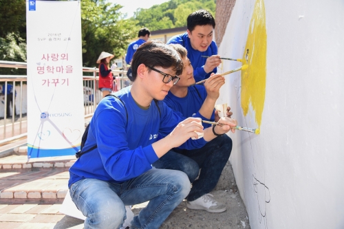 ▲효성의 부장, 차장 승격자들이 18일 명학초등학교의 노후한 담벼락에 새롭게 페인트를 칠하고 벽화를 그리고 있다.
 (사진제공=효성 )
