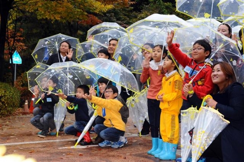 ▲현대모비스는 2010년부터 한국어린이안전재단과 함께 어린이용 투명우산을 제작해 매년 10만개씩 전국 초등학교와 복지시설 등에 배포하고 있다. 어린이들이 투명우산을 사용하며 즐거워하고 있다. 사진제공 현대모비스