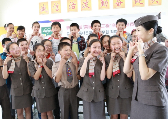 ▲지난 14일 중국 장쑤성 옌청시 서양현에 위치한 ‘신탄소학교’에서 열린 '아름다운 교실' 자매결연 행사에서 아시아나항공 캐빈승무원이 학생들에게 '미소 짓기' 교육을 실시하고 있다. 사진제공 아시아나항공