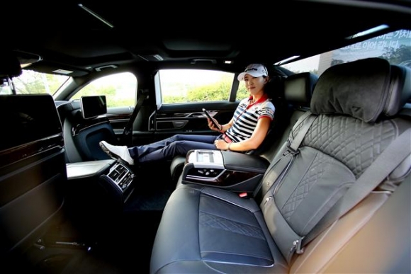 ▲윤채영이 BMW 레이디스 챔피언십 의전차량인 BMW 뉴 730Ld xDrive에 앉아 태블릿 PC인 터치 커멘드로 경기 결과를 확인하고 있다. 사진=JNA 정진직 포토
