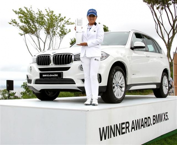 ▲고진영이 부상으로 받은 BMW X5와 함께 우승 트로피를 들고서 포즈를 취하고 있다.사진=JNA 정진직 포토