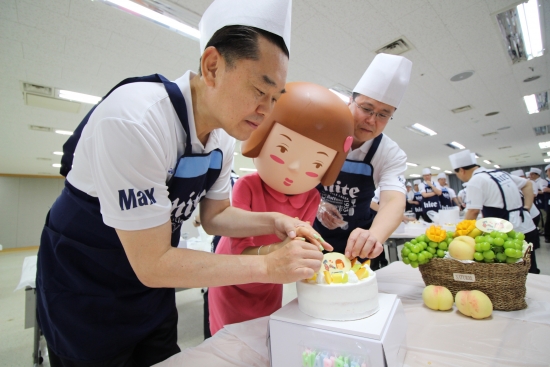 ▲김인규 대표 외 임직원이 소외계층을 위한 생일케이크를 만들고 있다.(사진제공=하이트진로)