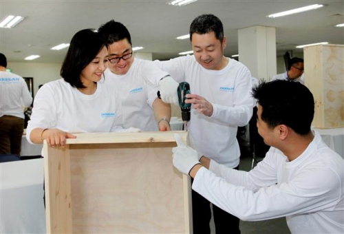 ▲박정원 두산그룹 회장(오른쪽 두번째)이 4월 ‘두산인 봉사의 날’ 행사에서 임직원과 함께 가구 만들기 작업을 하고 있다. 사진제공 두산