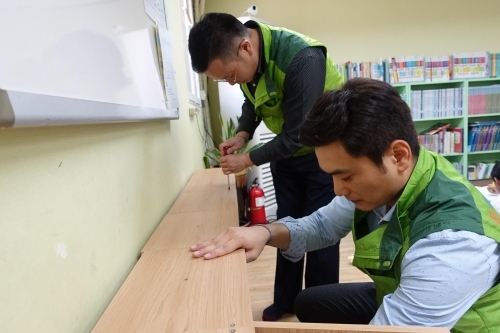 ▲코오롱그룹 임직원들이 7일 단합행사에서 제작한 사물함을 지역아동센터를 찾아 직접 설치하고 있다.(사진제공=코오롱그룹 )