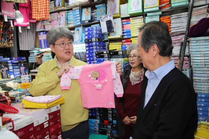 ▲14일 유경준 통계청장(왼쪽)이 수원 남문시장 내의점을 방문해 어린이용 내복을 펼쳐보고 있다.(통계청)