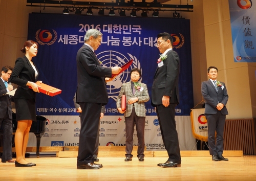 ▲오카다 나오키 올림푸스한국 사장(오른쪽)이 나눔과 기부봉사 활동의 공을 인정받아 정진규 한국국제연합봉사단 후원회장(왼쪽)으로부터 '2016 대한민국 세종대왕 나눔 봉사 대상'을 수여받고 있다.(사진제공=올림푸스)