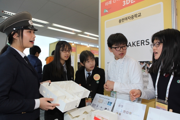 ▲용현여자중학교 부스 에서 3D 프린터를 활용해 제작과정 설명듣는 학생들 모습(제공=포스코건설)