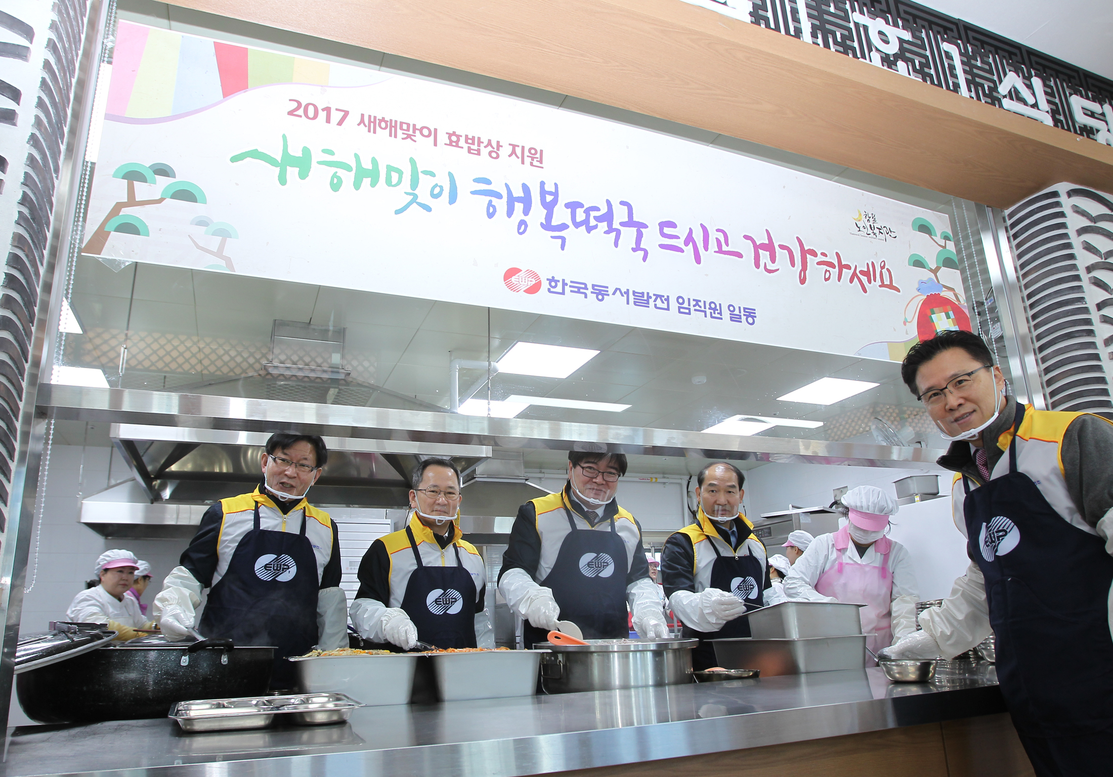 ▲떡국 배식 중인 동서발전 경영진(왼쪽부터 차례로 이경로 미래사업단장, 박희성 전략경영본부장, 김용진 사장, 국중양 기술경영본부장, 표영준 기획전략처장)(사진=한국동서발전)