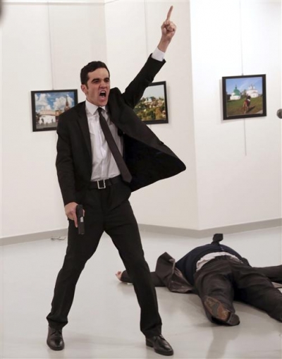 ▲총격범 알튼타시가 안드레이 카를로프 터키주재 러시아대사를 총격으로 쓰러뜨린 후 손을 들어보이고 있는 모습. AP연합뉴스