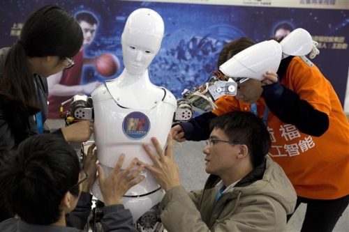 ▲중국 베이징에서 지난해 10월 21일(현지시간) 열린 세계 로봇 컨퍼런스 기간 학생들이 직접 개발한 휴머노이드형 로봇 ‘아레스’를 점검하고 있다. 베이징/AP뉴시스