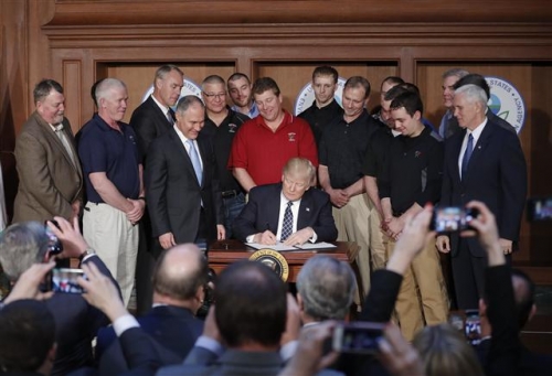 ▲도널드 트럼프 미국 대통령이 28일(현지시간) 워싱턴 환경보호청 본부를 방문해 광산 근로자들이 보는 가운데 '에너지 독립' 행정명령에 서명을 하고 있다. 사진=AP뉴시스