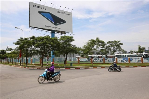 ▲삼성전자가 베트남 전체 경제성장에 지대한 영향을 미치고 있다. 베트남 박닌 성 옌퐁산업단지에 있는 삼성 스마트폰 공장 앞에 갤럭시S7 엣지 광고판이 서 있다. 블룸버그  