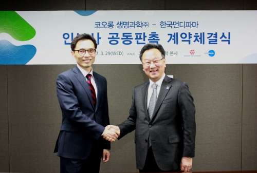 ▲이명세 한국먼디파마 사장(왼쪽)과 이우석 코오롱생명과학 대표